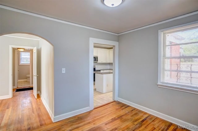 interior space featuring crown molding and light hardwood / wood-style floors