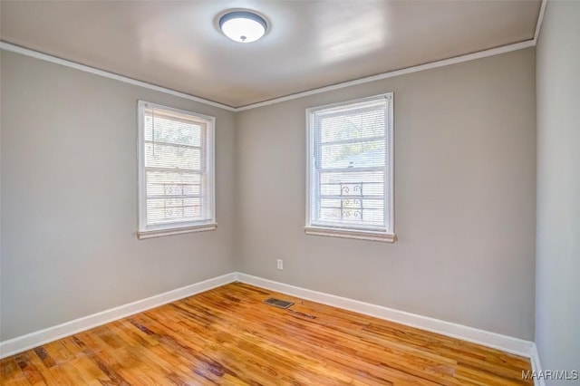 empty room featuring crown molding and light hardwood / wood-style flooring