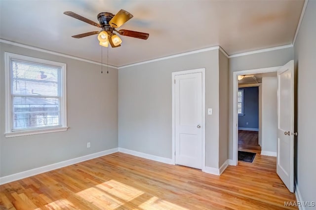 empty room with ornamental molding, light hardwood / wood-style flooring, and plenty of natural light