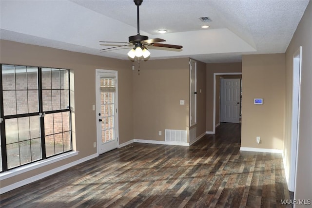 spare room with dark wood-type flooring, ceiling fan, and a textured ceiling