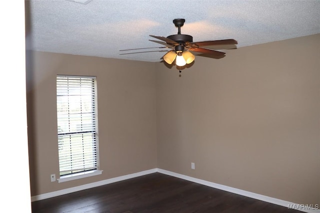 spare room with ceiling fan, dark wood-type flooring, and a textured ceiling