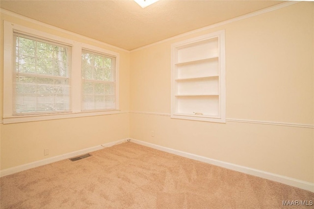 unfurnished room with crown molding, carpet flooring, a textured ceiling, and built in shelves