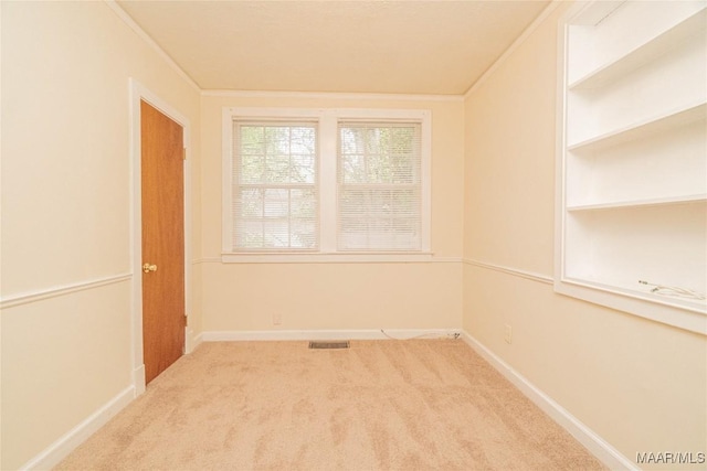 carpeted spare room with crown molding