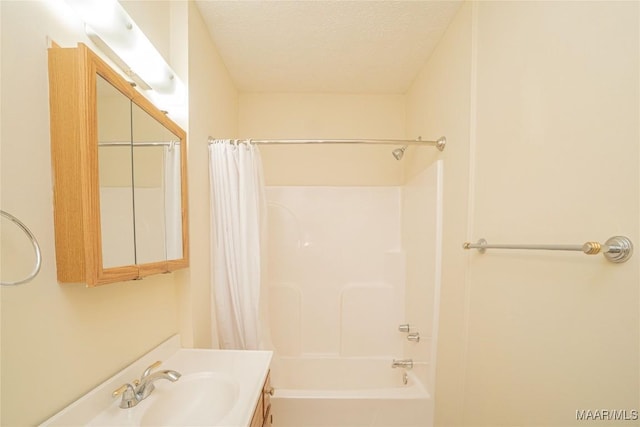 bathroom featuring vanity, shower / bathtub combination with curtain, and a textured ceiling