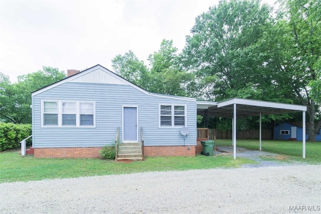 view of front of home with a front lawn and a carport