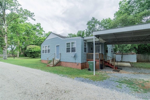 view of front of house with a carport and a front yard