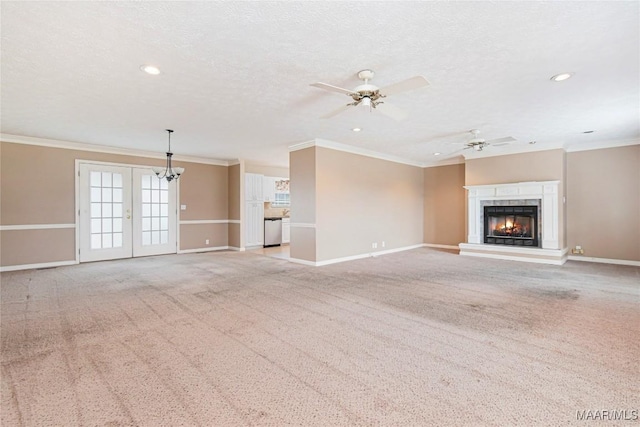 unfurnished living room with crown molding, light carpet, a textured ceiling, and french doors