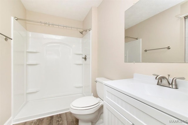 bathroom featuring vanity, hardwood / wood-style floors, toilet, and walk in shower