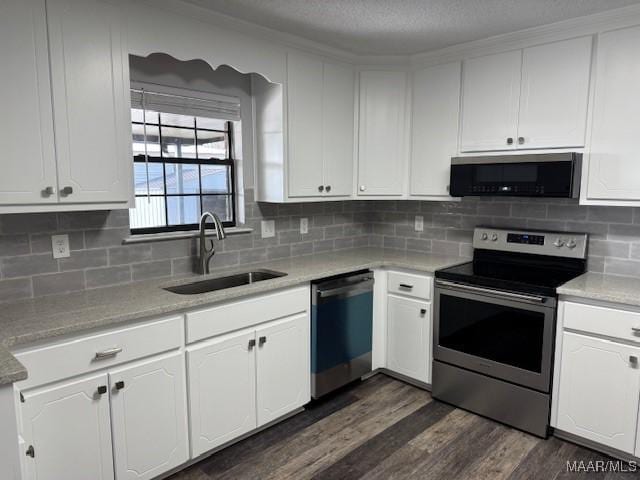 kitchen with stainless steel appliances, sink, white cabinets, and dark hardwood / wood-style floors