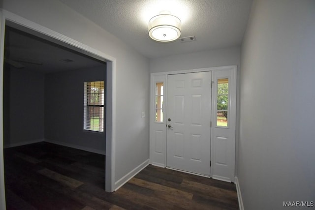 6515 Redland Rd, Wetumpka, AL 36093 - entryway with dark wood-style flooring, a textured ceiling, baseboards, and visible vents