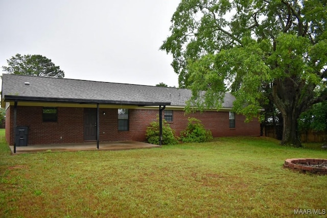 6515 Redland Rd, Wetumpka, AL 36093 - back of property with a patio, an outdoor fire pit, a lawn, a shingled roof, and brick siding