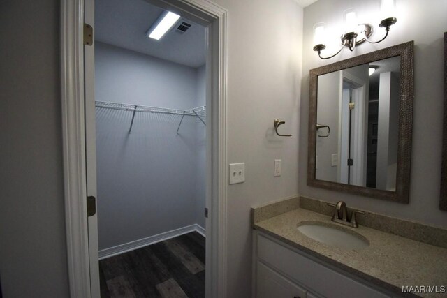 6515 Redland Rd, Wetumpka, AL 36093 - bathroom with a walk in closet, visible vents, wood finished floors, and vanity