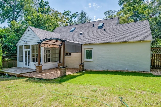 rear view of property featuring a yard, a pergola, and a sunroom