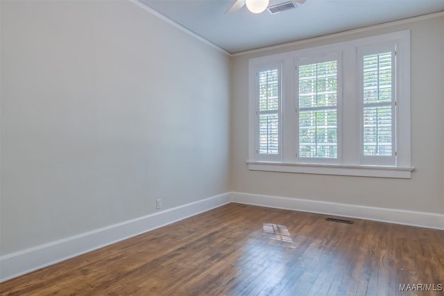 spare room featuring ornamental molding, dark wood-type flooring, and ceiling fan