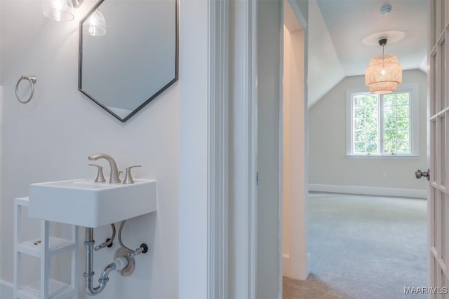 bathroom featuring lofted ceiling and sink