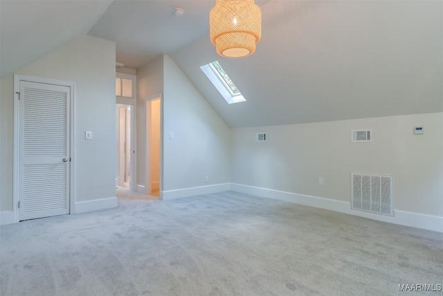 bonus room with vaulted ceiling with skylight and light colored carpet