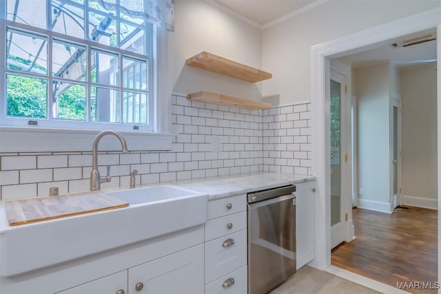 kitchen featuring backsplash, light stone countertops, ornamental molding, white cabinets, and stainless steel dishwasher