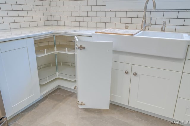 interior space with tasteful backsplash, tile patterned floors, and sink