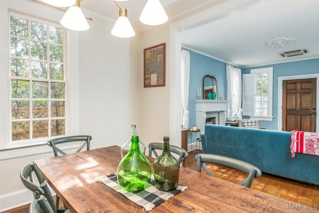 dining area with hardwood / wood-style flooring and ornamental molding