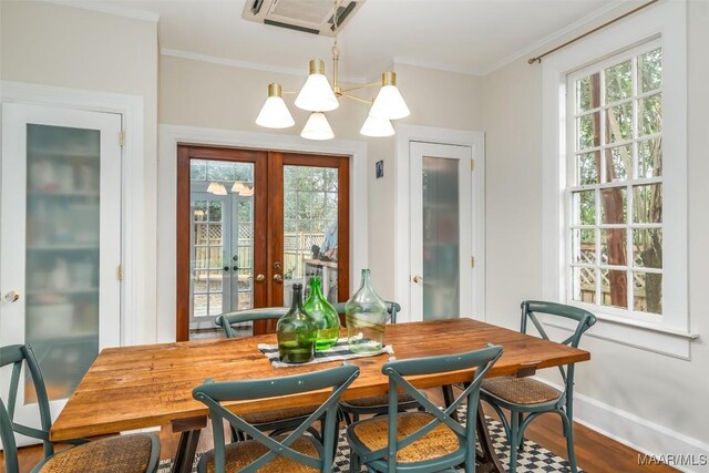 dining space featuring ornamental molding, plenty of natural light, wood-type flooring, and french doors