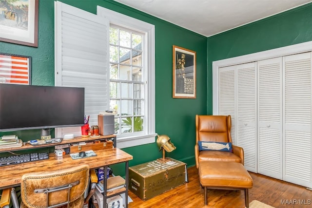 home office with wood-type flooring and a healthy amount of sunlight