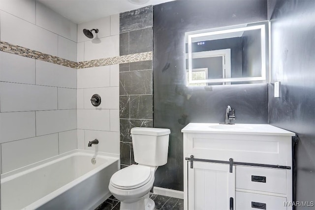 full bathroom featuring vanity, tiled shower / bath, and toilet