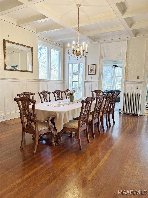 dining room with coffered ceiling, dark hardwood / wood-style flooring, radiator, and beam ceiling