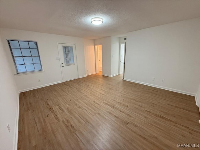 unfurnished room featuring hardwood / wood-style floors and a textured ceiling