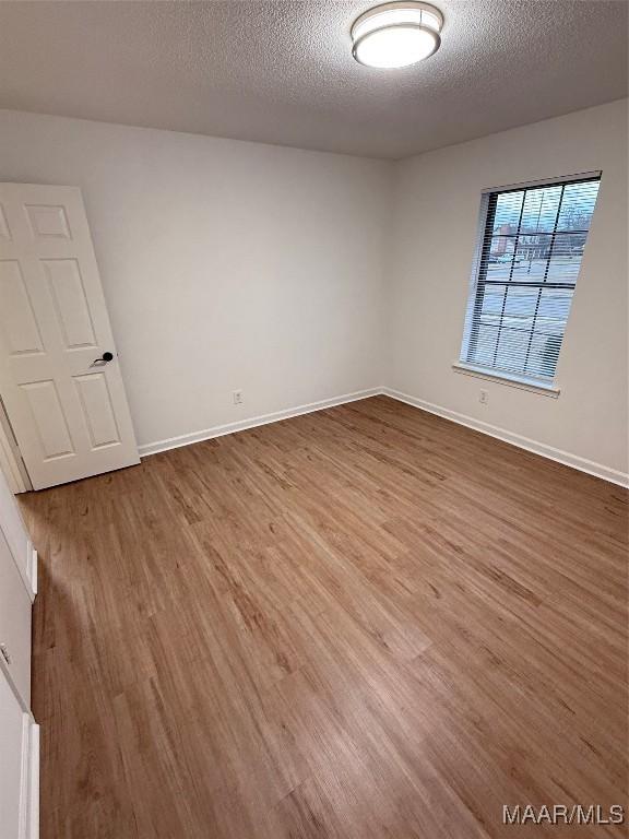 spare room with hardwood / wood-style floors and a textured ceiling