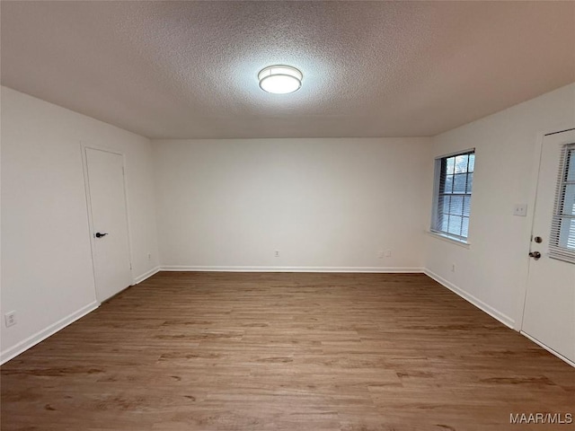 spare room featuring hardwood / wood-style floors and a textured ceiling