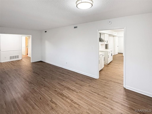 unfurnished room featuring hardwood / wood-style flooring and a textured ceiling