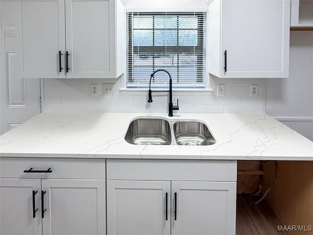 kitchen with sink, white cabinets, and light stone counters