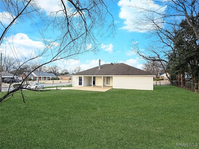 rear view of house featuring a yard and a patio