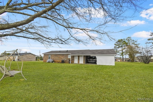 rear view of house featuring a yard