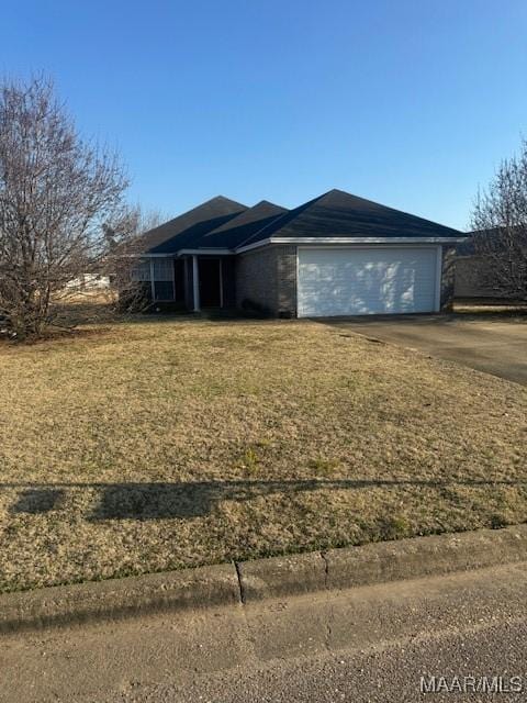 view of front of house featuring driveway, an attached garage, and a front yard