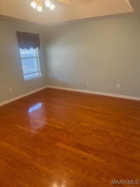 unfurnished room featuring ceiling fan, baseboards, and wood finished floors