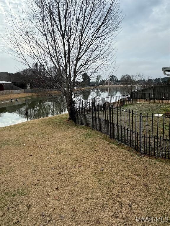 view of yard with a water view and fence