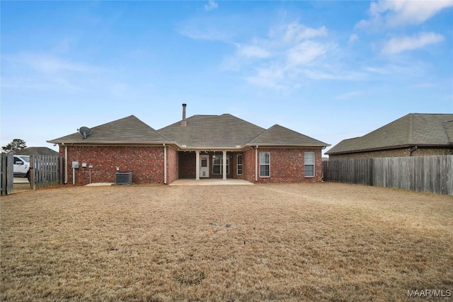 rear view of house with a lawn, cooling unit, and a patio area