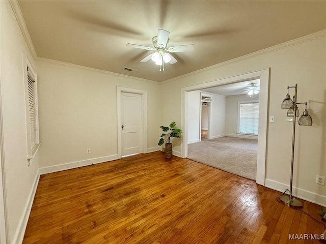 spare room with hardwood / wood-style flooring, ornamental molding, and ceiling fan