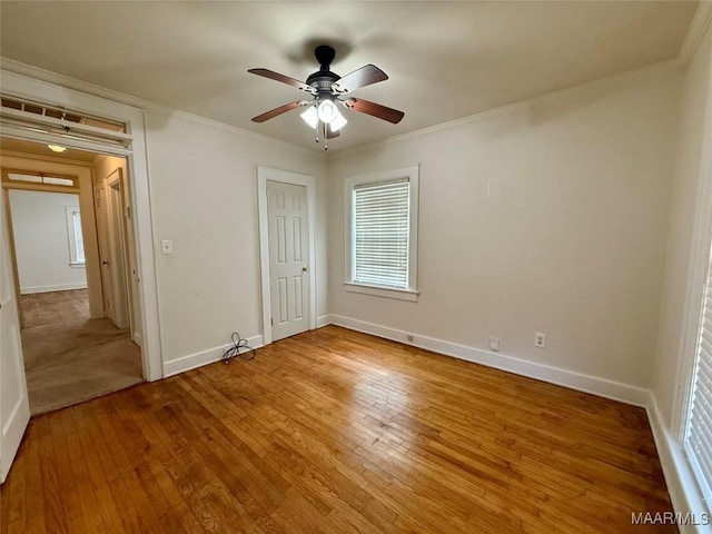 unfurnished bedroom with hardwood / wood-style flooring, ceiling fan, ornamental molding, and a closet