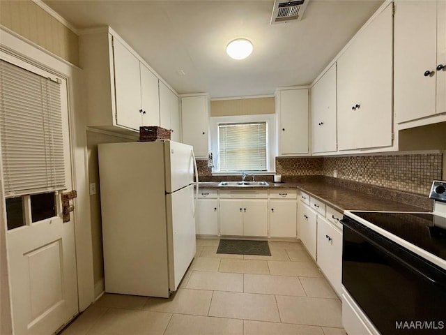 kitchen with white refrigerator, white cabinets, and electric stove