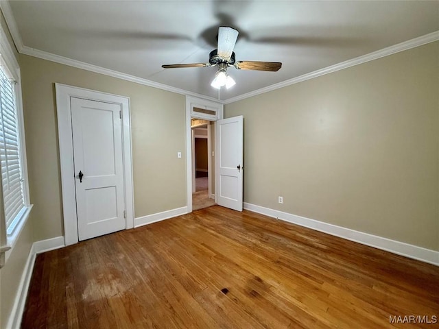 unfurnished bedroom with hardwood / wood-style floors, crown molding, and ceiling fan