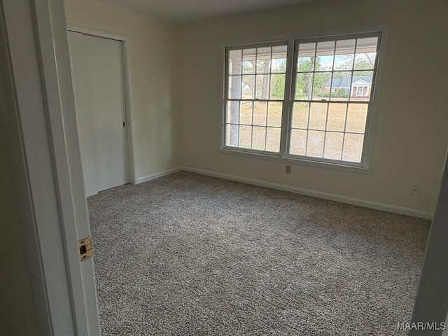 unfurnished room featuring plenty of natural light and carpet