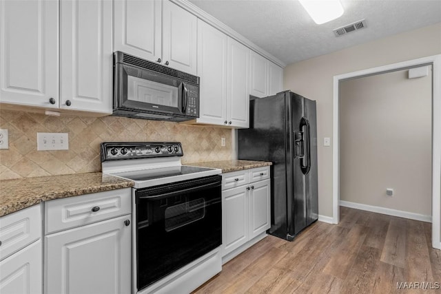 kitchen featuring white cabinets, light stone countertops, light hardwood / wood-style floors, and black appliances