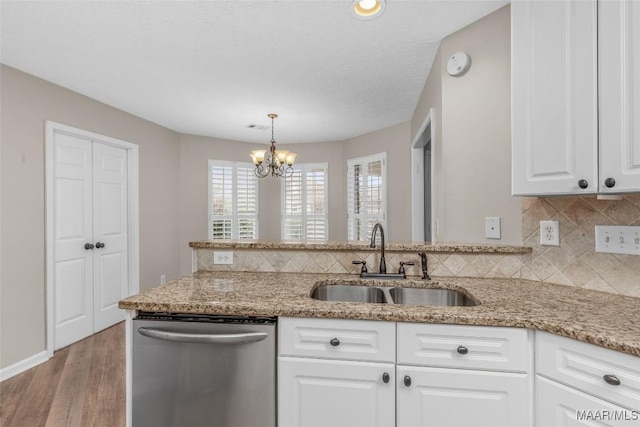 kitchen with sink, light stone counters, hanging light fixtures, dishwasher, and white cabinets