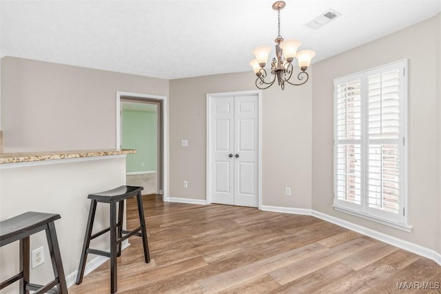 dining space featuring hardwood / wood-style floors and a chandelier