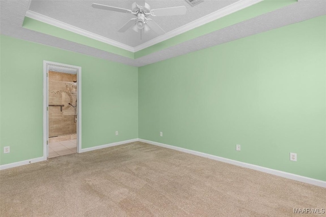 carpeted empty room featuring ceiling fan, ornamental molding, a raised ceiling, and a textured ceiling