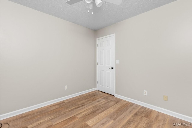 spare room with ceiling fan, light hardwood / wood-style floors, and a textured ceiling