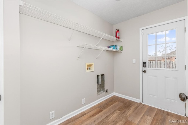 laundry room with washer hookup, wood-type flooring, and a textured ceiling