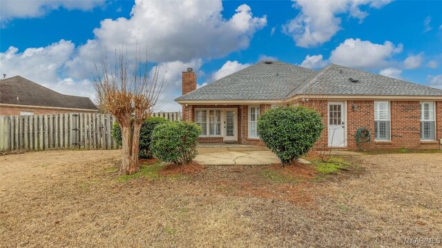 back of house with a patio area and a lawn